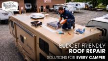 A Male Technician Repairing a Jayco Camper Roof Parked Outside of a Workshop