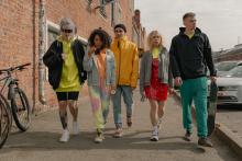 a-group-of-people-wearing-jackets-walking-together-on-pavement
