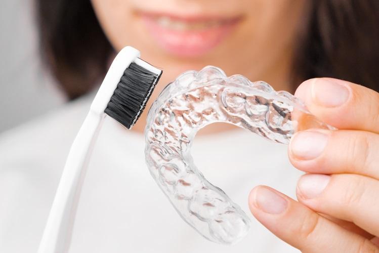 close-up-woman-showing-how-to-clean-clear-aligner