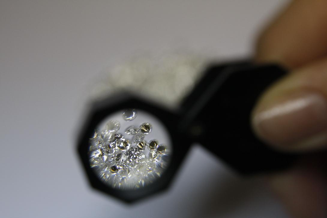Loose diamonds viewed through a jeweler's magnifying loupe